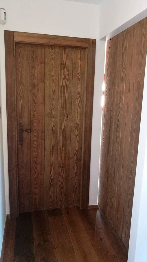 Fabricación artesanal de puertas de paso en madera maciza de pino, teñida, con guia vista decorativa en negro en Carpintería HP Murcia